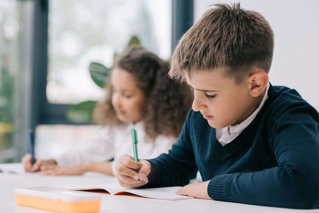 Young-boy-doing-his-school-work-in-class-min-1024x683